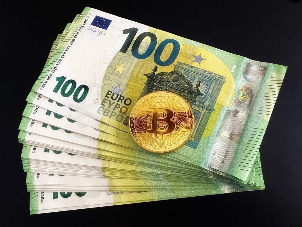 Picture: a Bitcoin sign on a hundred euro stacks